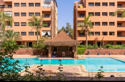 an empty swimming pool in front of a building at Sweet 1 Bed Room Appart in Marrakech