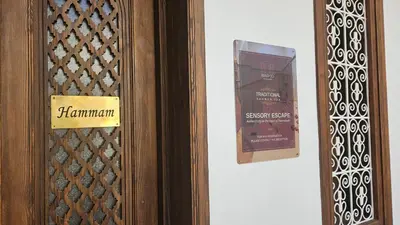 a wooden door with a sign on it next to a wall at Riad Jô & Spa in Marrakech