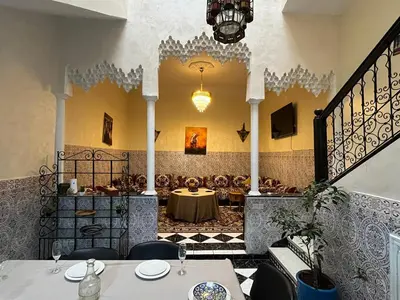a restaurant with a table in the middle of a room at Riad Flouris in marrakech in Marrakech