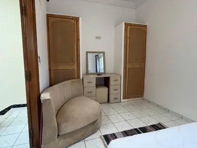 a bedroom with a chair and a dresser and a mirror at Riad Flouris in marrakech in Marrakech