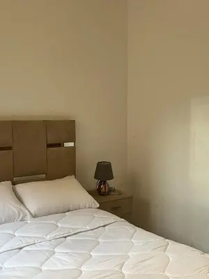 a bedroom with two beds and a lamp on a nightstand at Riad Flouris in marrakech in Marrakech