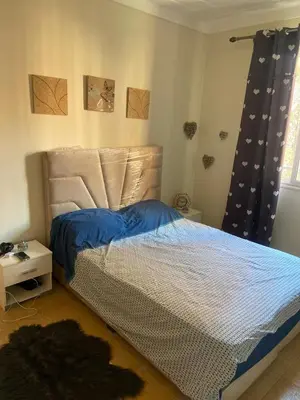 a bedroom with a bed with blue sheets and a window at Bel appartement 1er étage aux portes de gueliz in Marrakech