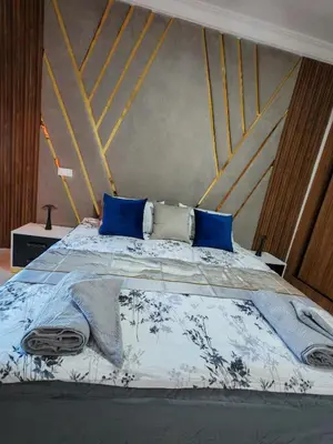 a bedroom with a bed with blue pillows at Elegant Apartment with King-Size Bed, Premium Amenities, 5 Pools & Free Parking in Marrakech