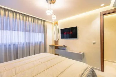 a bedroom with a bed and a television on the wall at Modern Jewel Central and Premium comfort in Marrakech