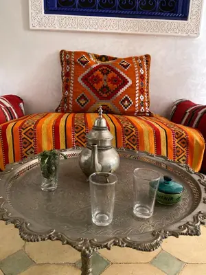 a living room with a coffee table with glasses on it at Riad des remparts d'agdal in Oulad Akkou