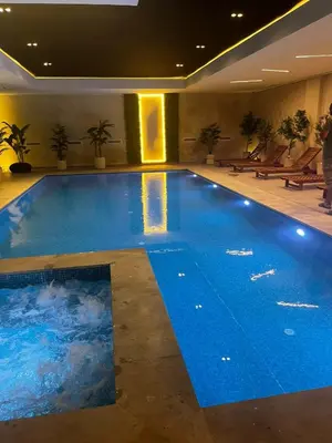a large swimming pool with blue water in a building at Jnane el Ali Gueliz in Marrakech