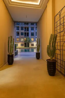 two cactus plants in a room with a swimming pool at Jnane el Ali Gueliz in Marrakech