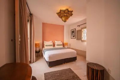 a bedroom with a bed and a chandelier at Riad Dar Amazonia in Marrakech