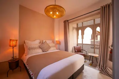 a bedroom with a bed and a large window at Riad Dar Amazonia in Marrakech