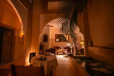 a dining room with a table and chairs in a building at Riad Dar Amazonia in Marrakech