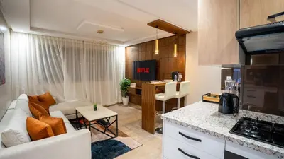 a kitchen and living room with a couch and a table at Stylish Gueliz Getaway, Terrace & Parking in Marrakech