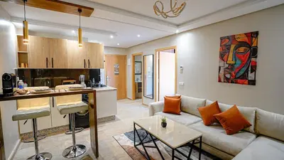 a living room with a couch and a kitchen at Stylish Gueliz Getaway, Terrace & Parking in Marrakech