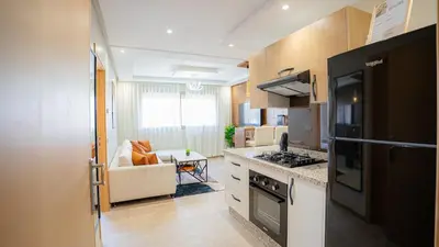 a kitchen with a stove top oven next to a couch at Stylish Gueliz Getaway, Terrace & Parking in Marrakech