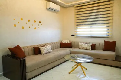 a living room with a couch and a glass table at apartment in the center for an excellent stay in Marrakech