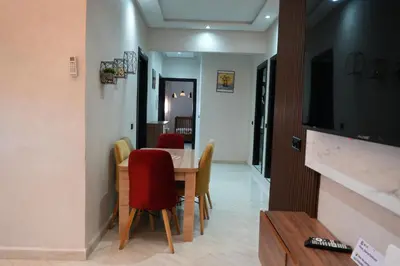 a dining room with a table and chairs and a television at apartment in the center for an excellent stay in Marrakech