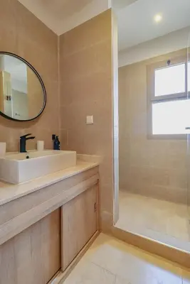 a bathroom with a sink and a mirror at New Charming apartment with swimming pool in Marrakech