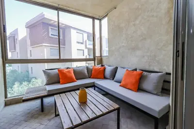 a couch in a room with a large window at New Charming apartment with swimming pool in Marrakech