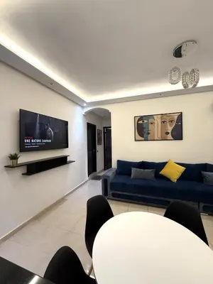 a living room with a blue couch and a tv at Appartement chic près de Guéliz Calme & confort à Marrakech in Marrakech