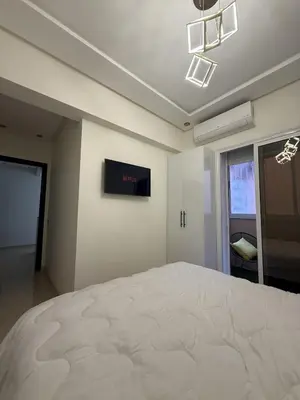 a bedroom with a bed and a tv on the wall at Appartement chic près de Guéliz Calme & confort à Marrakech in Marrakech