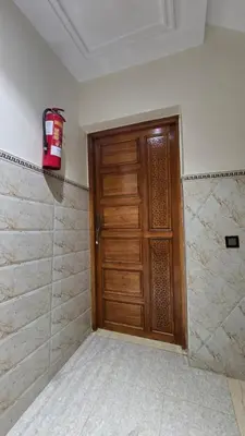 a bathroom with a wooden door and a fire extinguisher at Near Airport hosting in Marrakech