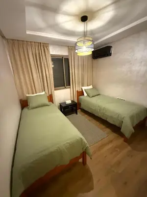 a bedroom with two beds and a ceiling at Appartement Marrakech 2 Chambres De Luxe Marron in Marrakech