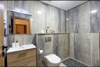 a bathroom with a toilet and a sink and a mirror at Appartement Marrakech 2 Chambres De Luxe Marron in Marrakech