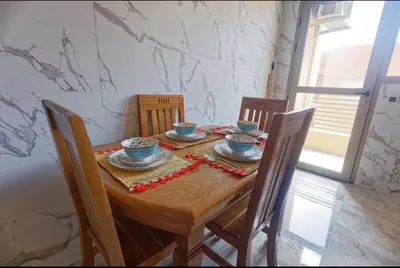 a wooden table with bowls and plates on it at Appartement Marrakech 2 Chambres De Luxe Marron in Marrakech