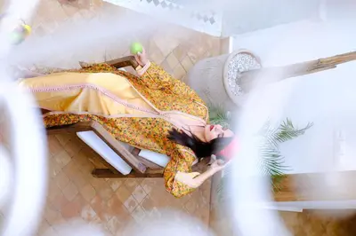 a woman in a yellow dress laying on a chair at Riad Zellige in Marrakech