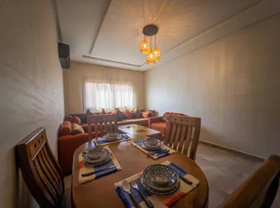 a dining room with a wooden table and chairs at Appartement Marrakech 2 Chambres De Luxe Orange in Marrakech