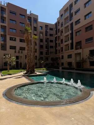 a fountain in a courtyard in front of a building at New apartment in Jnane El Guéliz in Marrakech