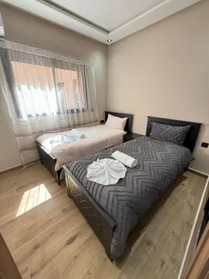 a bedroom with two beds and a window at Appartement centre ville Marrakech avec Piscine in Marrakech