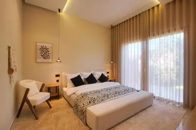 a bedroom with a bed and a chair and a window at Villa Marrakech in Marrakech