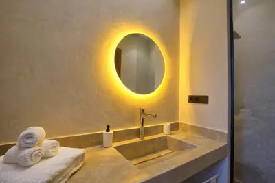 a bathroom with a sink with a mirror and towels at Villa Marrakech in Marrakech