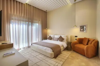 a bedroom with a bed and a chair at Villa Marrakech in Marrakech