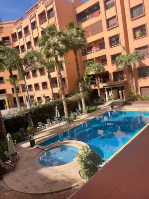 a swimming pool in front of a large building at Royal Pool Apartment Hivernage Marrakech in Marrakech