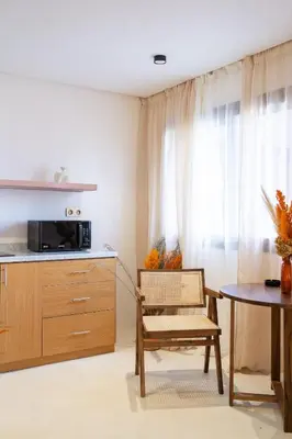 a kitchen with a table and a chair and a microwave at Refined studio in the city center! in Marrakech