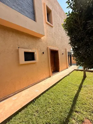 a building with a grass yard in front of it at Villa Aliya in Marrakech