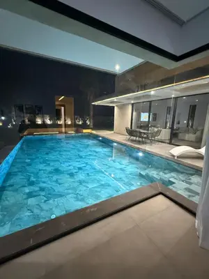a large pool with blue water in a building at Ayline house in Marrakech