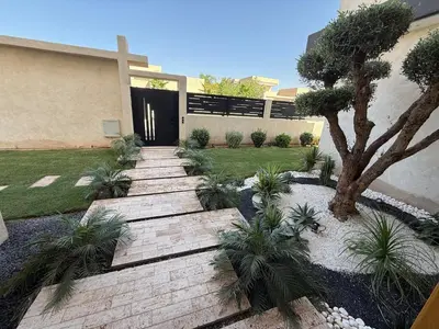 a garden with a wooden pathway in front of a house at Ayline house in Marrakech