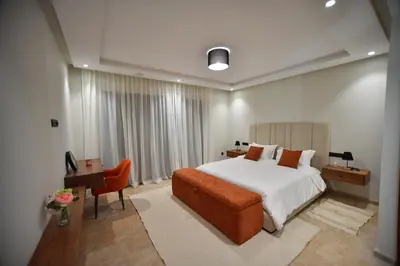 a bedroom with a bed and a desk and a chair at Luxury villa with heated pool and Hamam in Marrakech