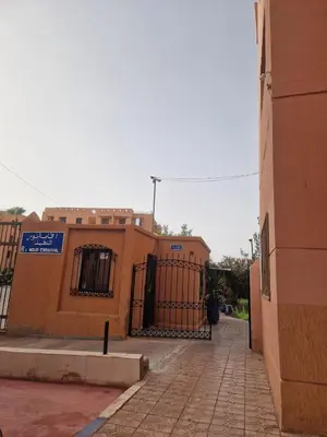 a building with a gate on the side of it at Appartement 2 chambres, piscine, vue palmeraie in Marrakech
