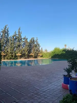 a resort with a swimming pool in the background at Appartement 2 chambres, piscine, vue palmeraie in Marrakech