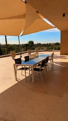 a table with chairs and a large umbrella at CASA EDEN - Serenity and elegance between Atlas mountains and city center in Marrakech