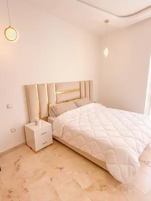 a bedroom with a large bed and a night stand at Studio haut standing in Marrakech