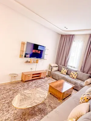 a living room with a couch and a tv at Studio haut standing in Marrakech