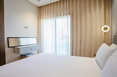 a bedroom with a white bed and a television at Your Tiny Paradise - Marrakech - Prestigia in Marrakech