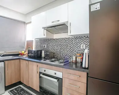 a kitchen with a stove and a refrigerator at The Art of Stay - Marrakech - Prestigia in Marrakech