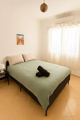 a bedroom with a large bed with green sheets at Cosy appartement 75m2 in Marrakech