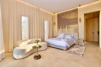 a bedroom with a bed and a chair at Villa youngLA in Sehib Foukani
