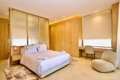 a bedroom with a bed and a chair and a desk at Villa youngLA in Sehib Foukani